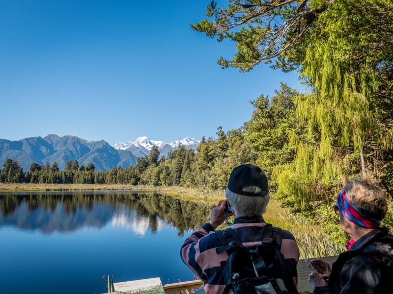 Promeneurs au bord du lac Matheson devant le mont Cook en Nouvelle-Zélande