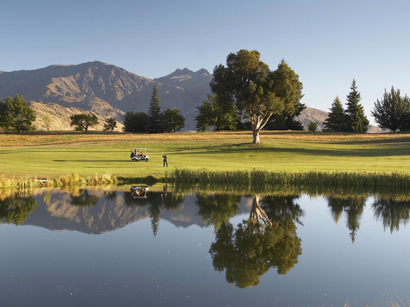 Un joueur de golf au bord d'un lac en Nouvelle-Zélande