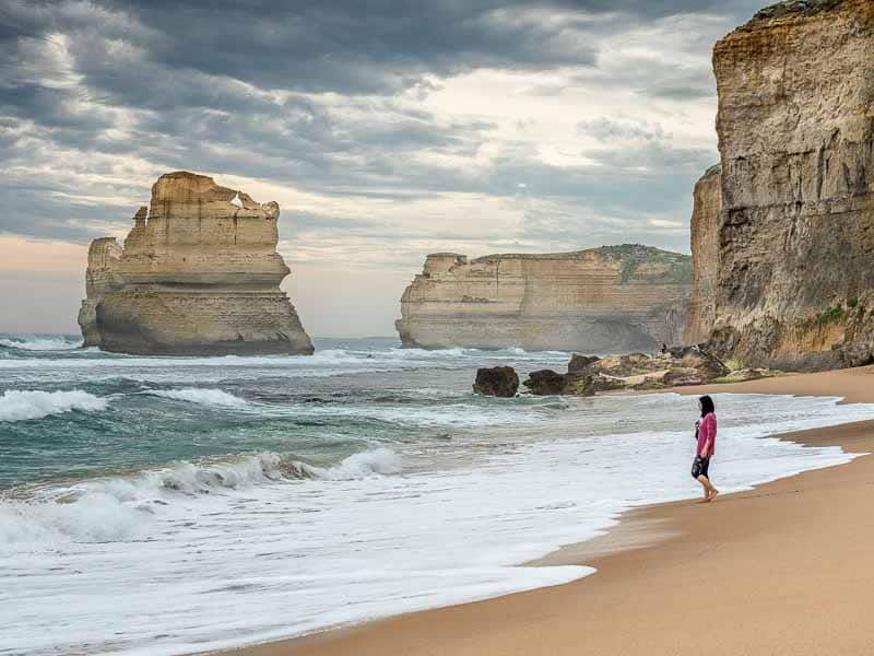 Une personne sur la plage au pied des falaises des 12 apôtres sur la Great Ocean Road en Australie