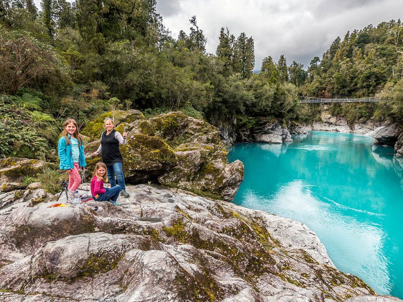 Famille au bord d'une rivière turquoise en nouvelle-zélande