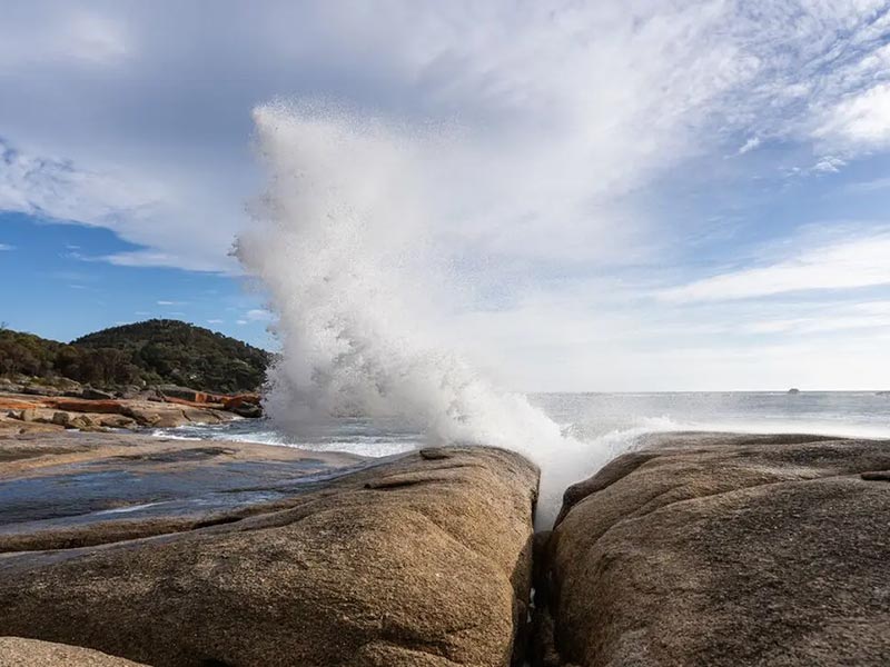 Vague giclant sur les rochers de la Bay of Fire en Tasmanie