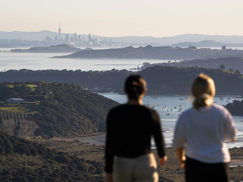 Deux personnes de dos regarde Auckland depuis l'île de Waiheke en Nouvelle-Zélande