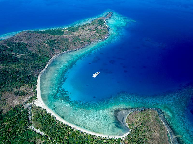 Vue aérienne d'un bateau de croisière dans un lagon des îles Fidji