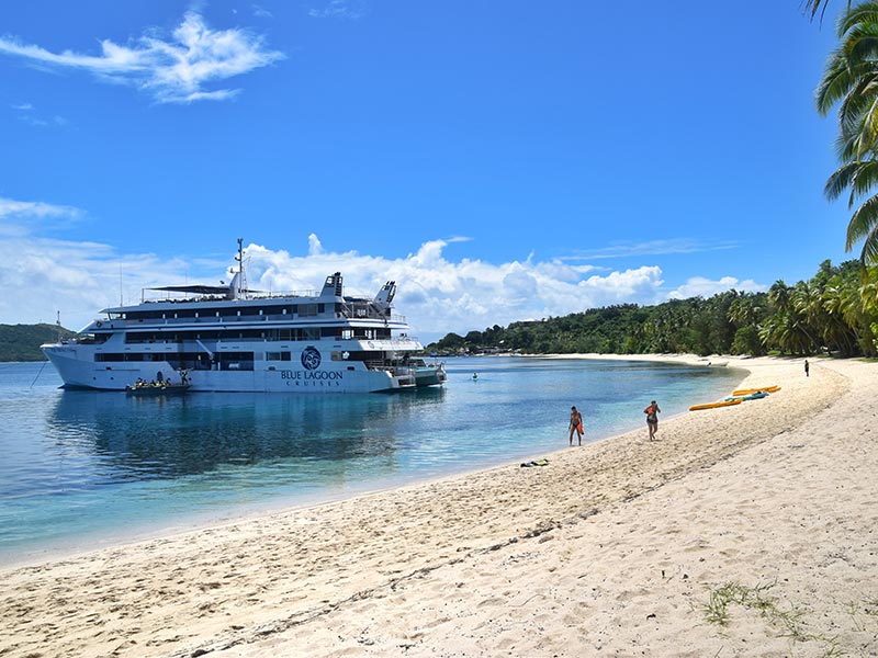 Bateau de croisière au bord d'une plage dans les îles Fidji