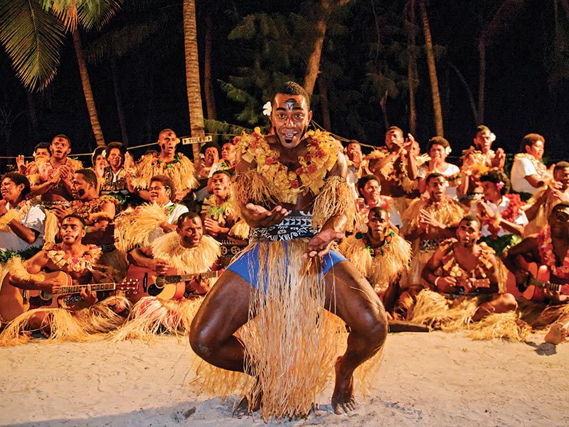 Danseur et chanteurs Fidjien en costume traditionnel sur une plage