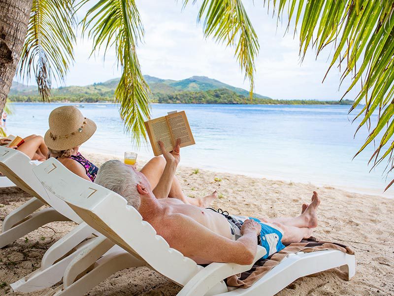 Deux personnes se reposent sur une chaise longue sur une plage des îles Fidji